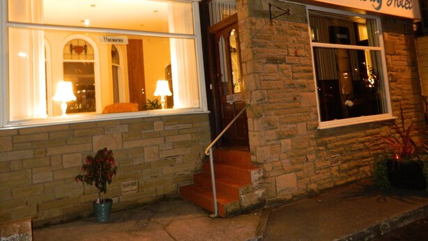 The exterior of Ocean Bay Hotel with a stone facade, large windows, and a sign above the entrance. - Ocean Bay Hotel (Blackpool)