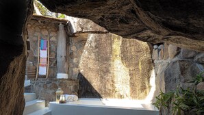 A stone-walled bathroom with a stone sink, a towel rack, and a lantern. - Kaya Mawa (Likoma Island)
