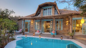A stone house with a swimming pool, open windows, and a thatched roof. - Kaya Mawa (Likoma Island)