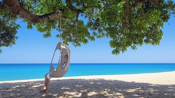 Een privéstrand, ligstoelen aan het strand, parasols, strandlakens