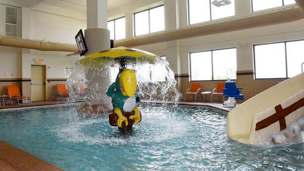 A water feature with a character in a green and yellow costume.