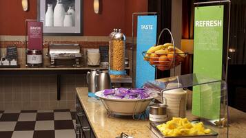 Disposição de buffet com diversos alimentos e uma máquina de café.