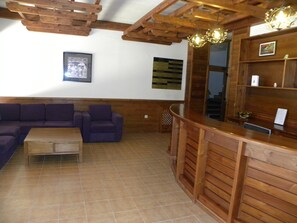A wooden interior with a reception desk, a sofa, and a framed picture on the wall. - St. Ivan Ski Resort (Bansko)