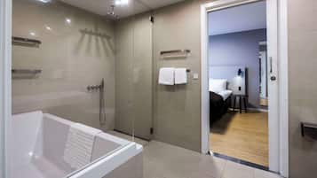 A modern bathroom with a bathtub, shower, and glass-enclosed shower area.