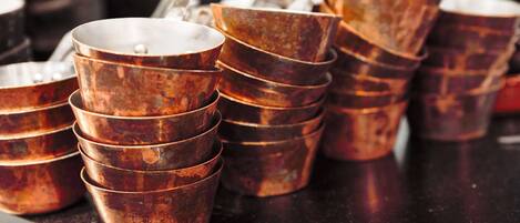Stacks of copper measuring cups on a counter.
