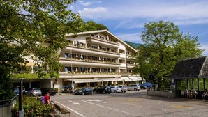 A multi-story hotel with outdoor seating and a parking area. - Christophs Hotel (Schenna)