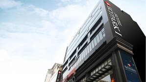 Un moderno edificio de hotel con un letrero llamativo que dice "Hotel Skypark".