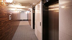 Un pasillo con paredes de madera, suelo alfombrado y un ascensor.