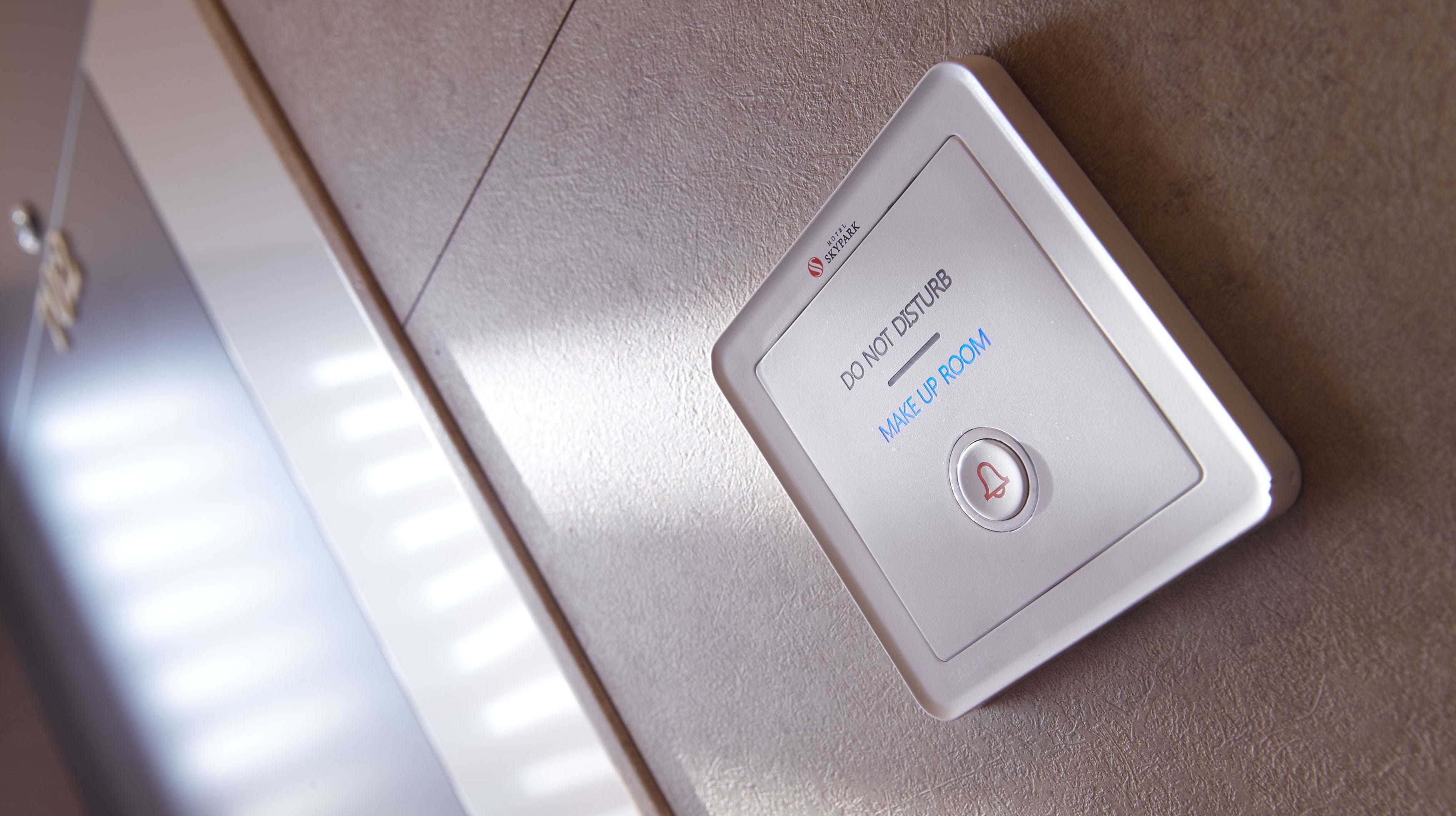 A hotel room control panel with a 'Do Not Disturb' button and a 'Make Up Room' button.