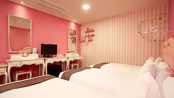 A pink-themed bedroom with a vanity, a bed, and a striped wall.