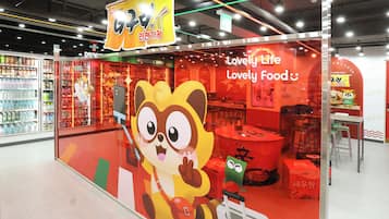 A brightly lit 7-Eleven store with a large cartoon character on the window.