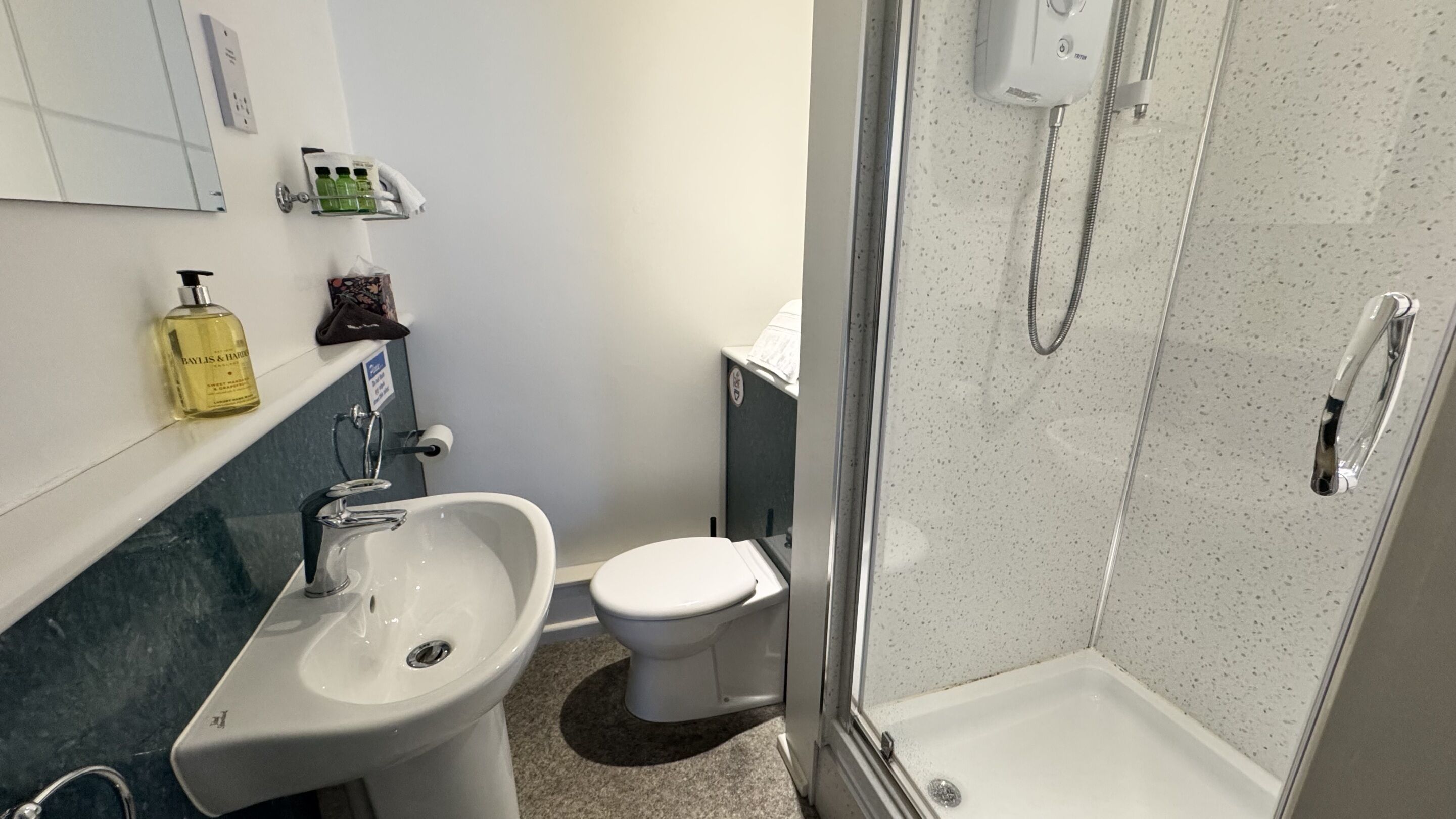 A bathroom with a sink, toilet, and shower.
