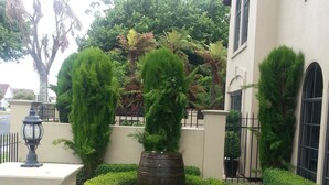 A well-maintained garden with neatly trimmed hedges, a central water feature, and a lamp post. - Tuscany Villas Rotorua (Rotorua)