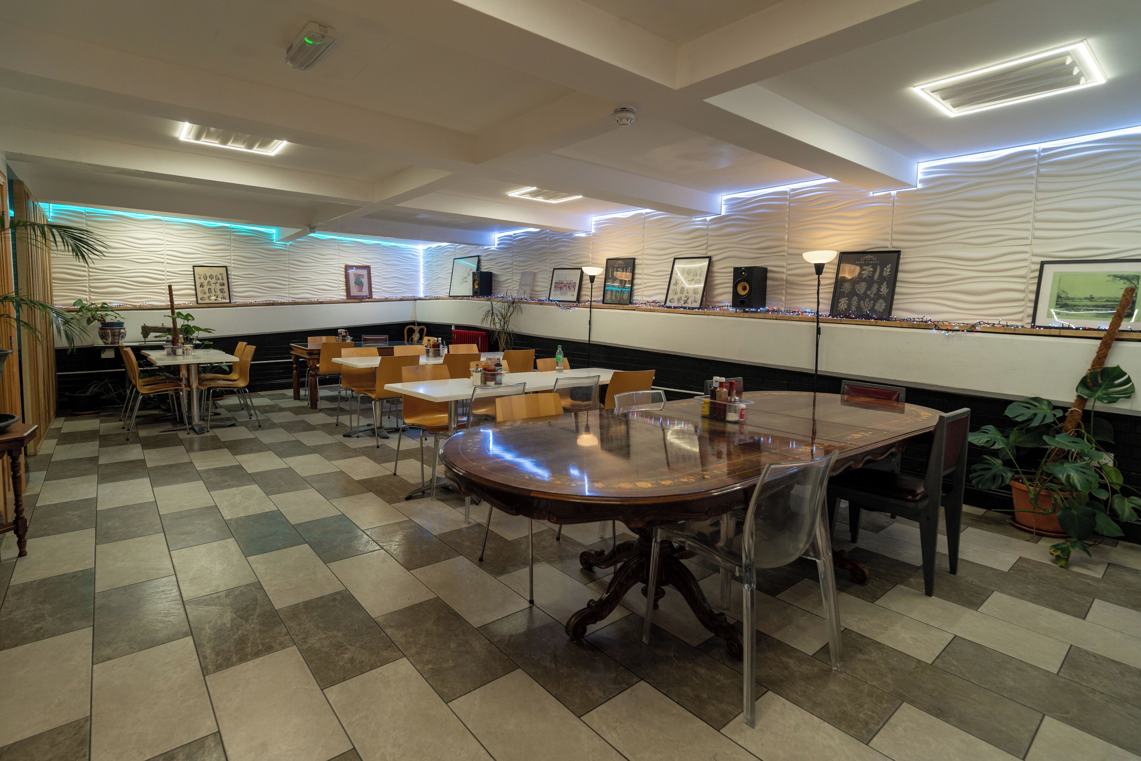 Un restaurant avec un sol à carreaux, des tables rondes et des chaises.
