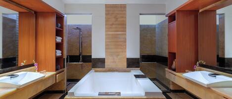 Une salle de bain moderne avec deux lavabos, une grande baignoire et des meubles en bois.
