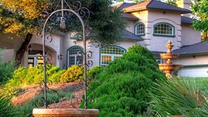 A large house with a fountain, surrounded by lush greenery and a well-maintained garden. - Bella Vista Bed and Breakfast (Placerville)