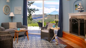 A living room with a sofa, chairs, a fireplace, and a view of the outdoors. - Bella Vista Bed and Breakfast (Placerville)