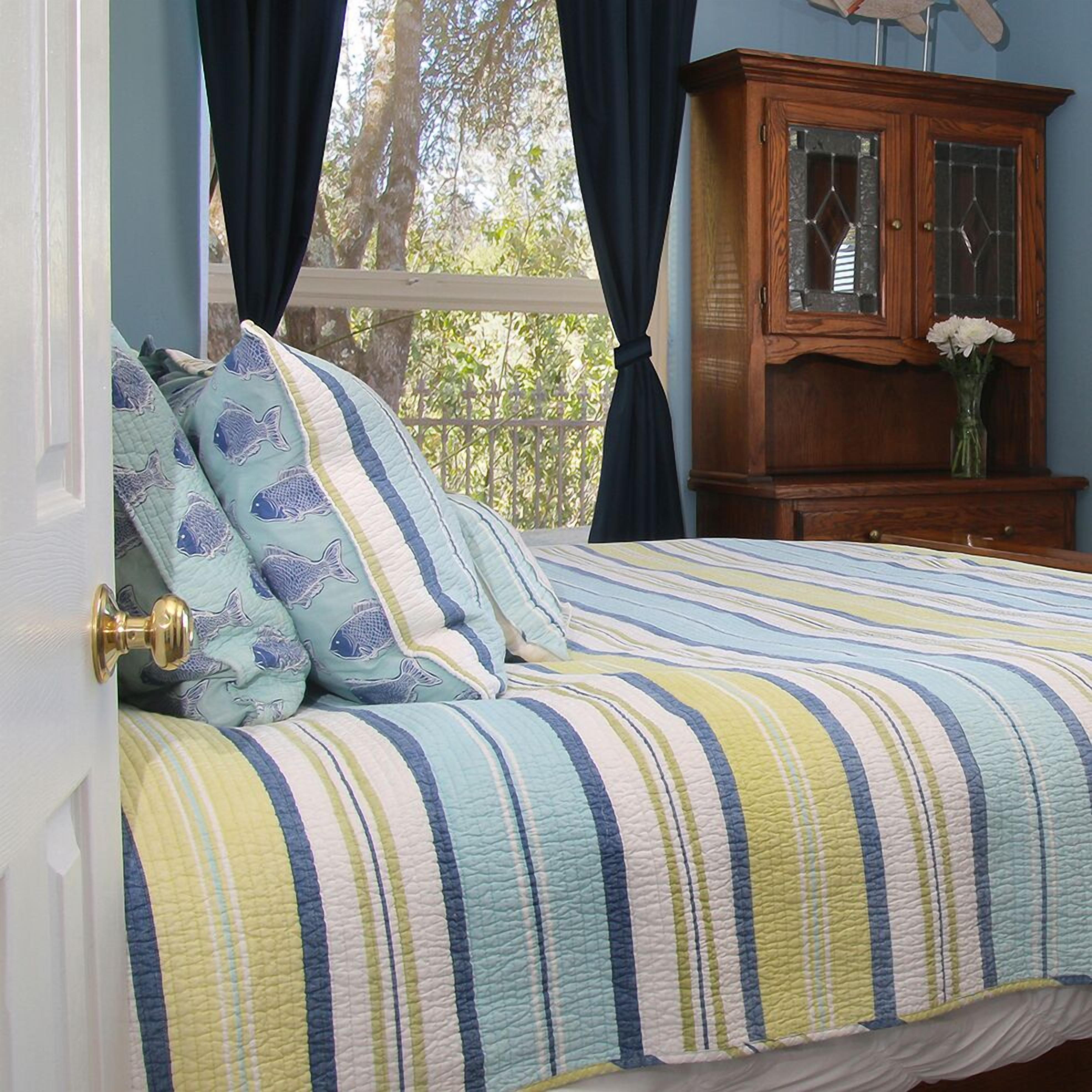 A bedroom with a bed, a wooden cabinet, and a window with curtains.