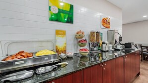 Ein Buffet mit verschiedenen Speisen, einer Kaffeemaschine und einem Schild, das auf heiße Speisen hinweist.