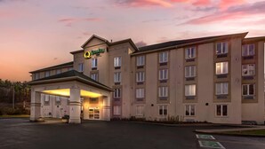 A multi-story hotel with a covered entrance and a sign indicating 'Quality Inn.'