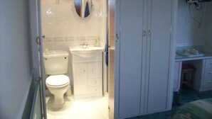 Une salle de bain avec des toilettes, un lavabo et un miroir.
