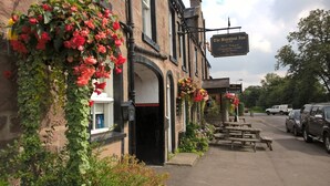 Le Bankfoot Inn est un pub traditionnel à la façade noire, aux murs couverts de lierre et doté d’un espace extérieur accueillant où l’on peut s’asseoir.