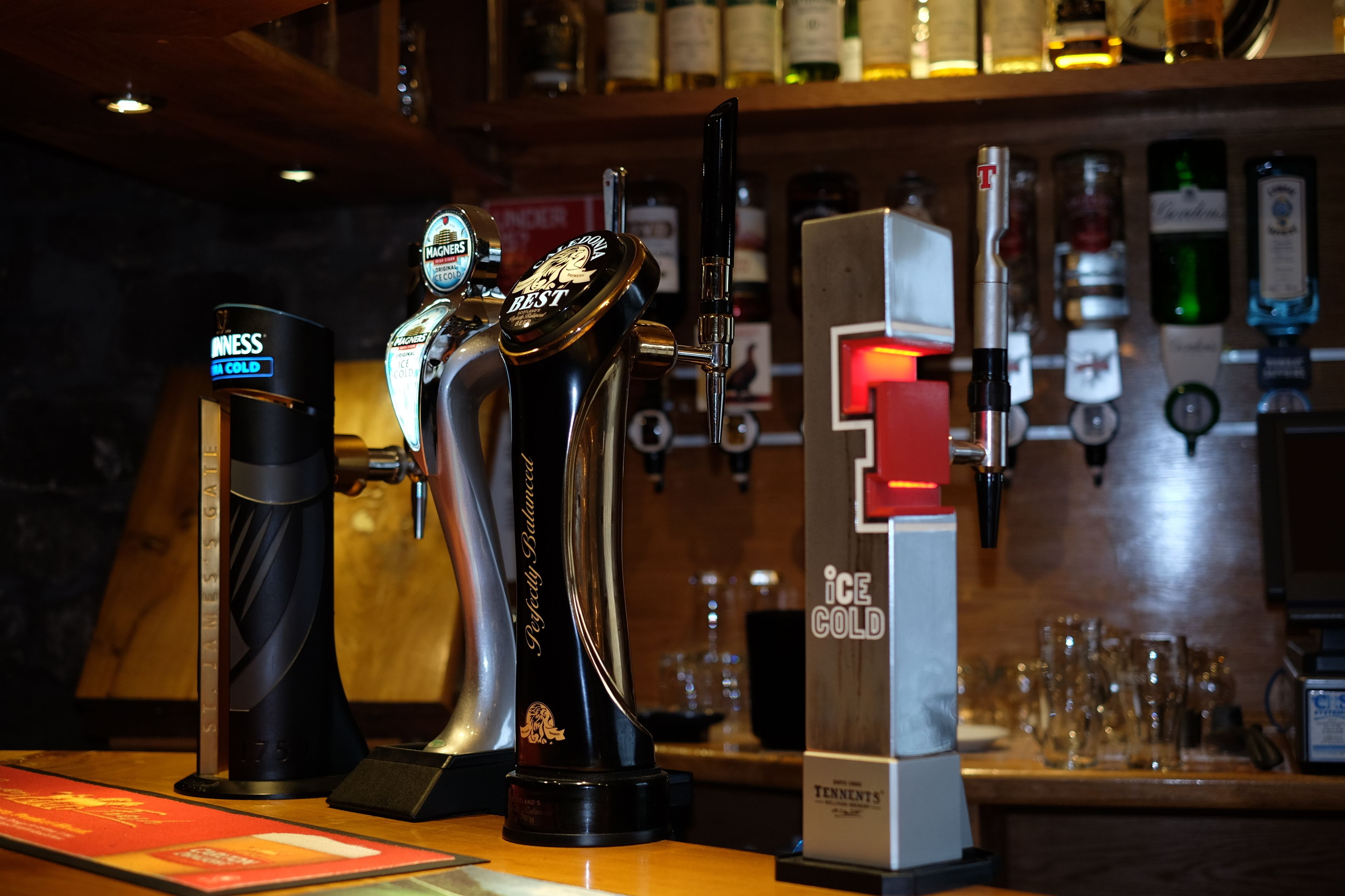 A bar area with a tap labeled "TENNENTS" and another labeled "ICE COLD".