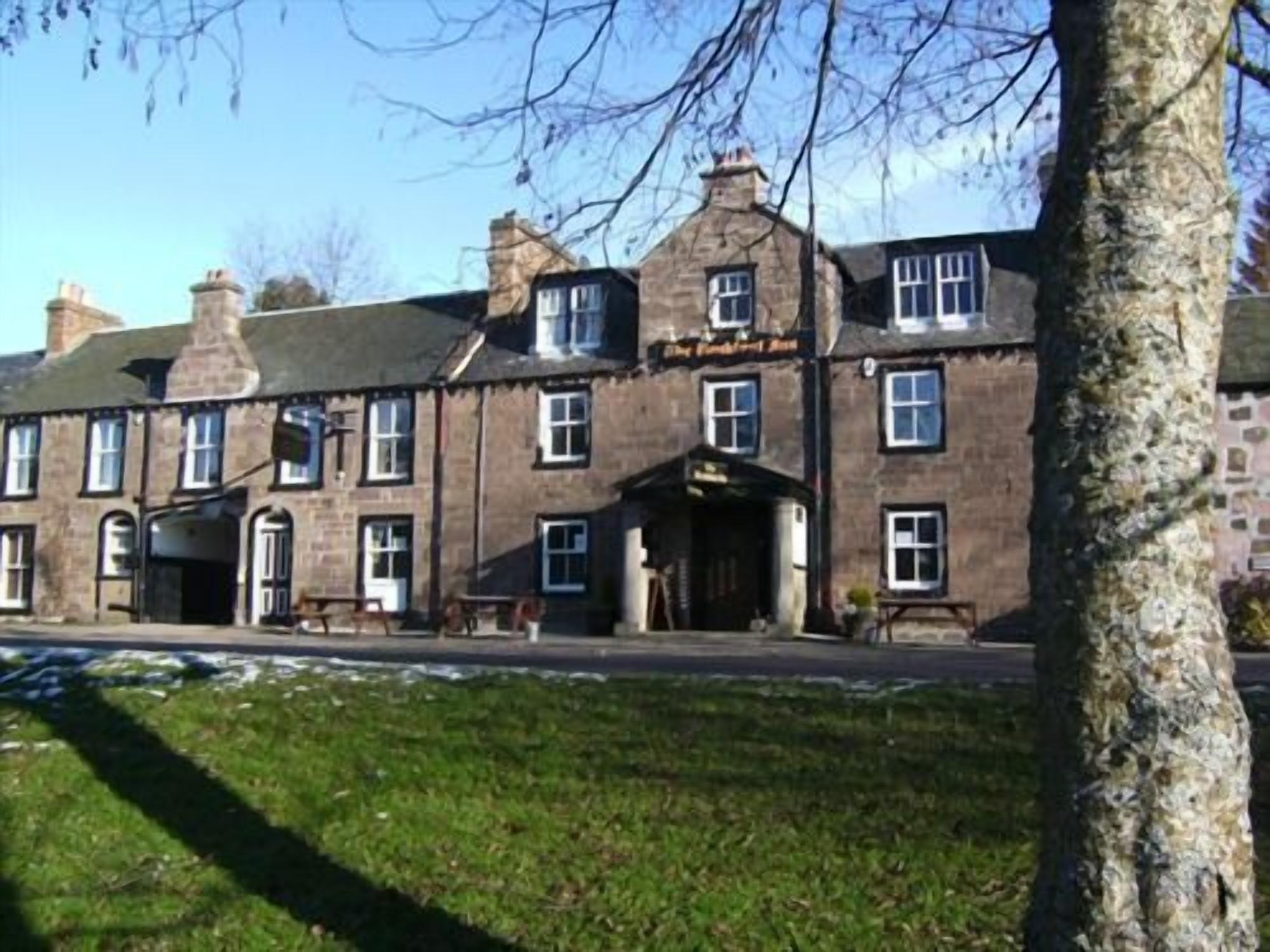 A traditional stone building with multiple windows and a central entrance.