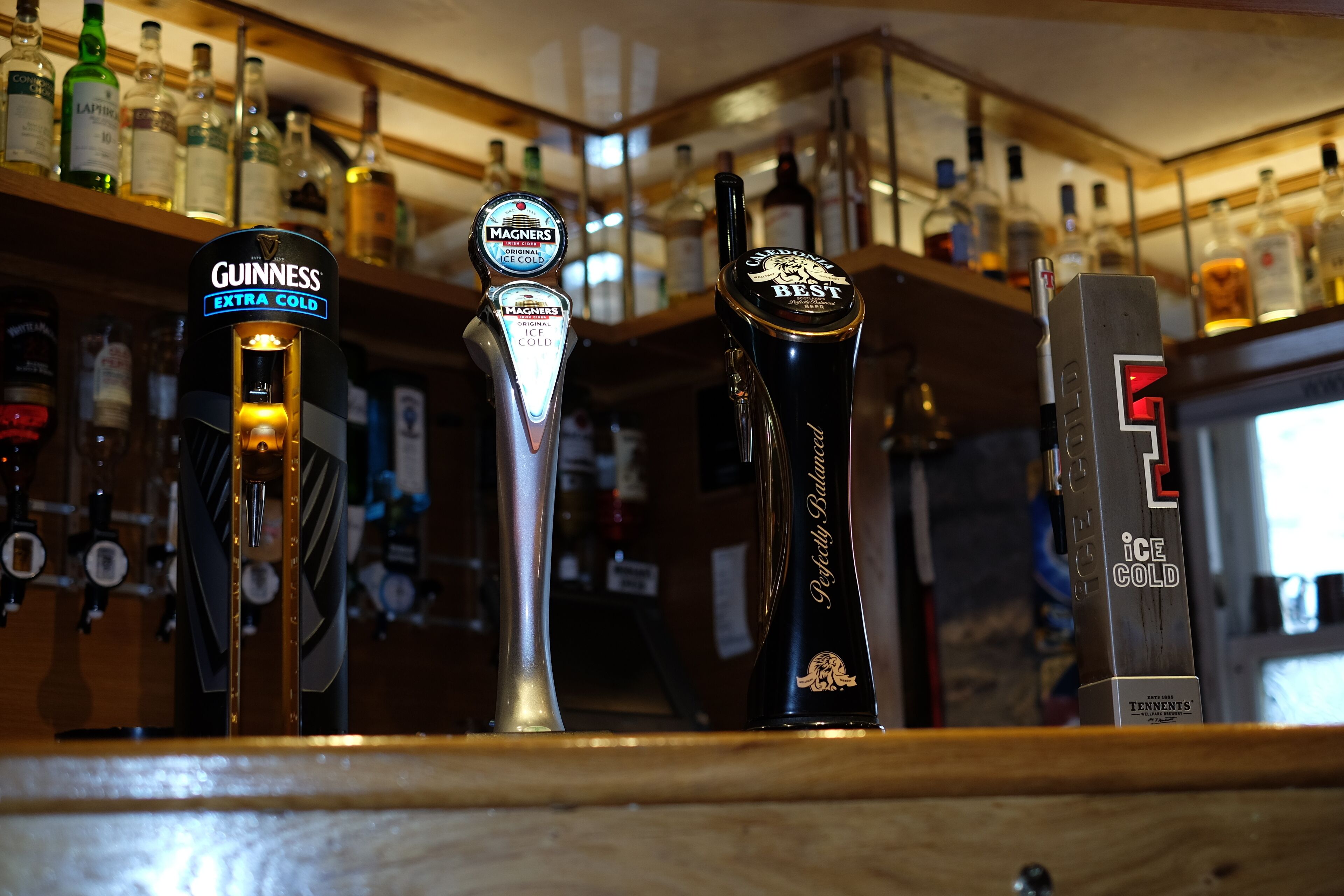 Un bar con tres grifos etiquetados Guinness, Magners y Best, y una máquina que indica 'hielo glacial'.