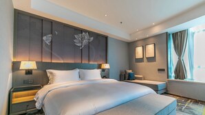 Una habitación de hotel moderna con una cama grande, mesitas de noche, un escritorio y una ventana con cortinas.