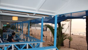 A beachside restaurant with blue and white decor, outdoor seating, and a view of the beach. - Cuba Agonda (Canacona)