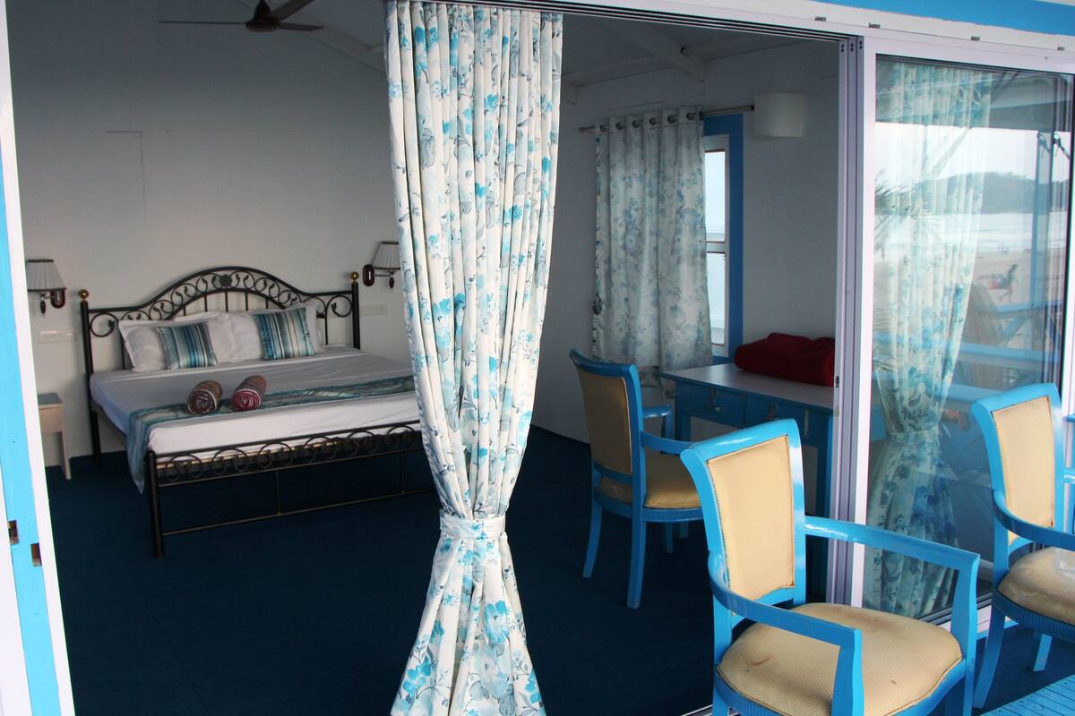 Una habitación con una cama, un escritorio y sillas.