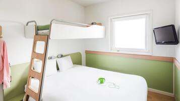 Habitación con literas, una escalera, una ventana y una diadema verde sobre la cama.
