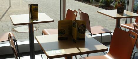 Un restaurant doté d’une terrasse avec des tables et des chaises.