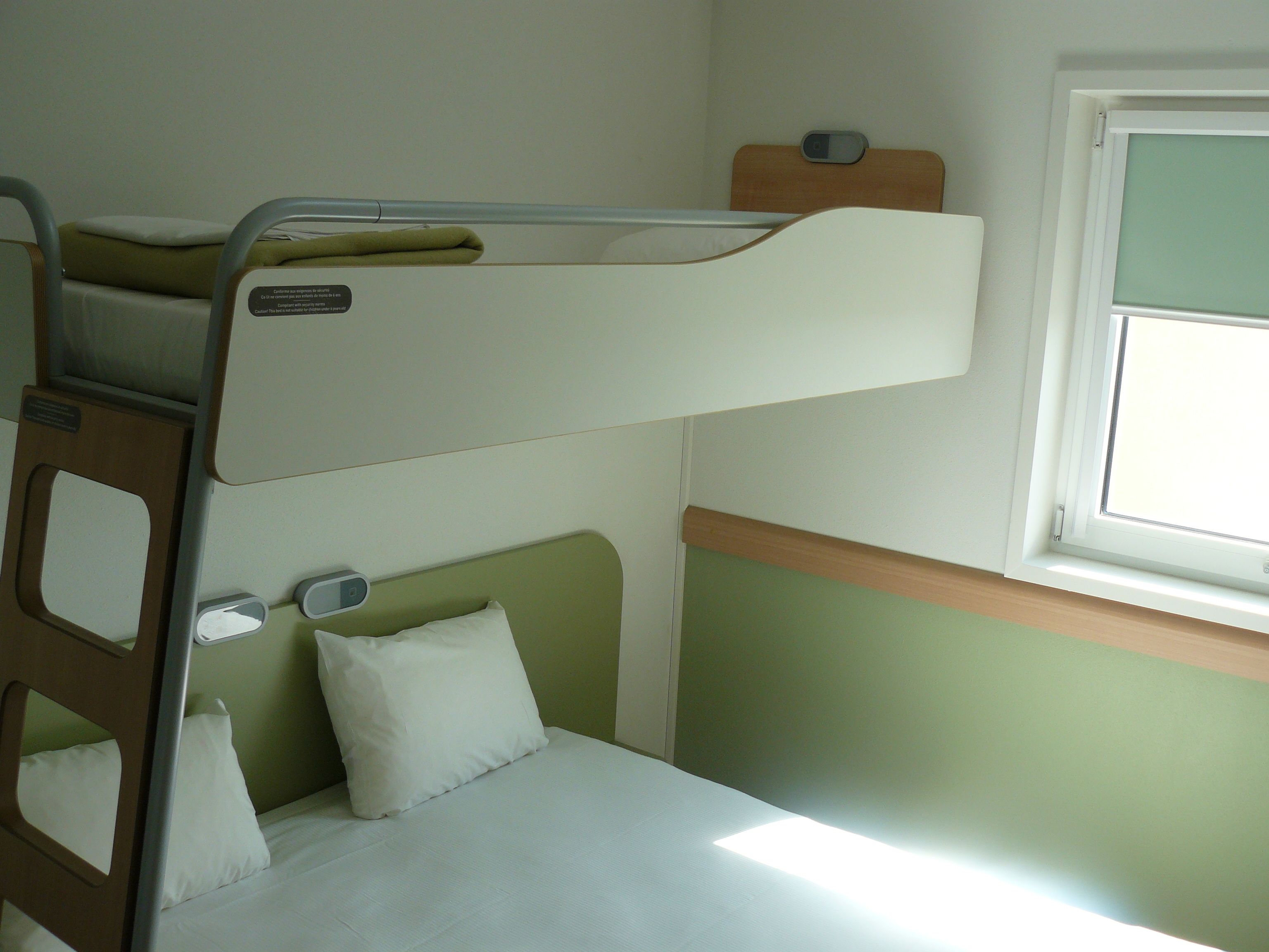 A bunk bed with a window above it.