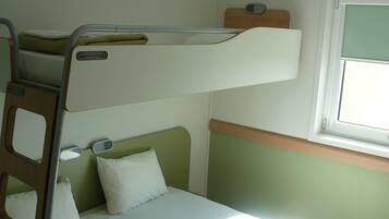 A bunk bed with a window above it.