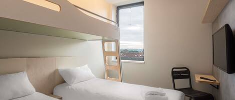 A modern hotel room with two beds, a TV, a desk, and a window with a city view.