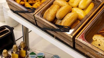 A buffet with various baked goods and condiments.