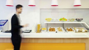 A buffet counter with various food items and a person serving.