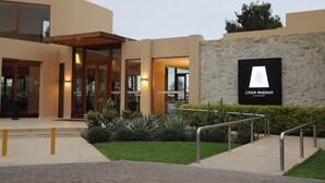 A modern building with a stone facade and a sign reading "CASA ANDINA STANDARD". - Casa Andina Standard Chincha (Sunampe)