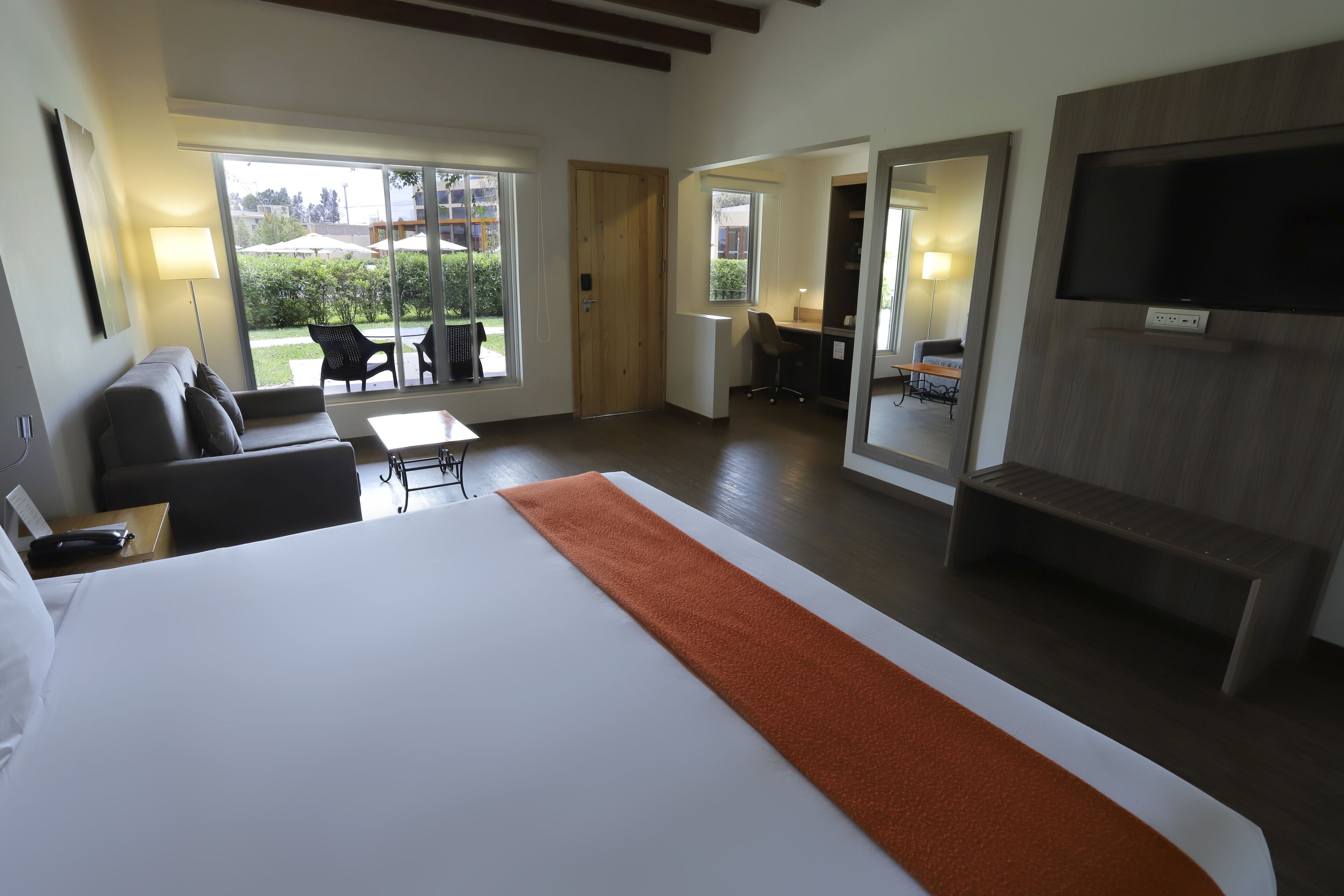 Una habitación de hotel con una cama grande, un escritorio, una silla y un televisor.