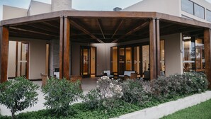 A modern building with a covered patio area, a fireplace, and a seating arrangement. - Casa Andina Standard Chincha (Sunampe)