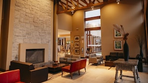 A spacious living area with a stone wall, a fireplace, and modern furniture. - Casa Andina Standard Chincha (Sunampe)