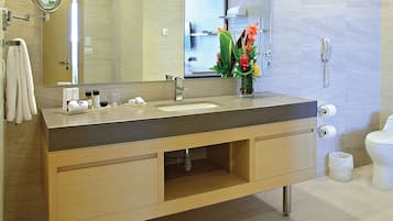 Ein modernes Badezimmer mit einem Holzlagerflansch, einem Waschbecken, einem Spiegel, einer Toilette und einem Telefon.