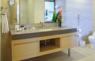 Ein modernes Badezimmer mit einem Holzlagerflansch, einem Waschbecken, einem Spiegel, einer Toilette und einem Telefon.