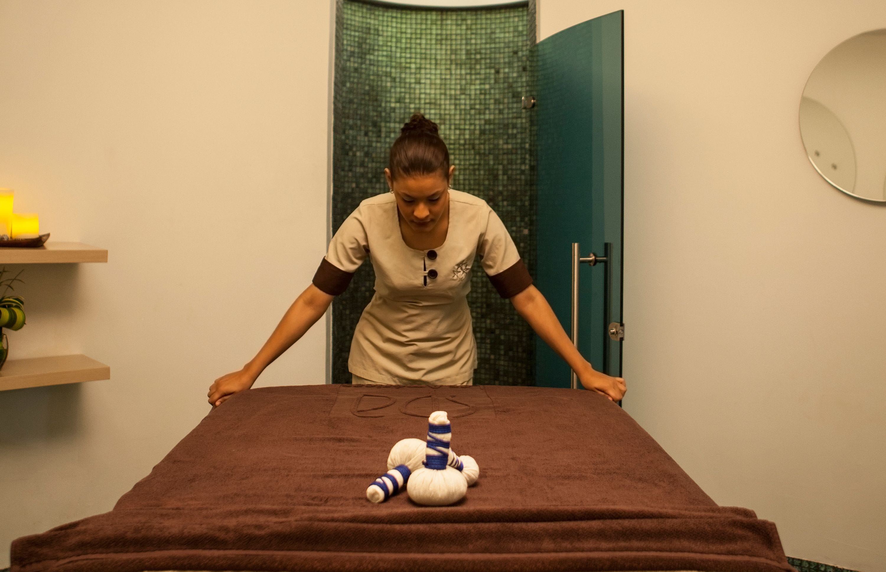 A massage table with a towel, a massage tool, and a green door in the background.