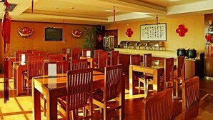 En restaurang med bord och stolar i trä, en bardisk och traditionell inredning.