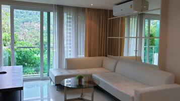 Suite, 2 habitaciones, vista al jardín | Área de sala de estar | Televisión de pantalla plana