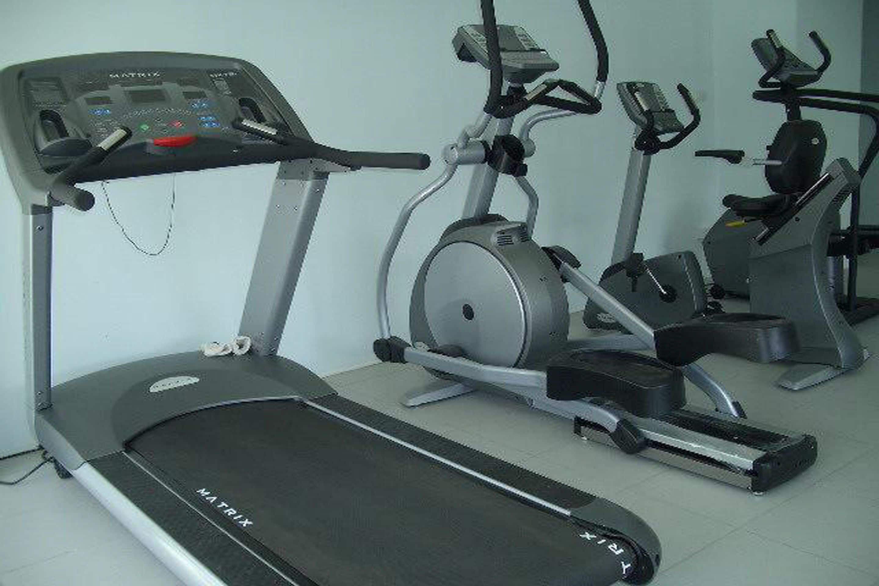 A treadmill and elliptical machine in a gym.