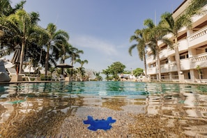 Una piscina al aire libre, sombrillas, sillones reclinables de piscina